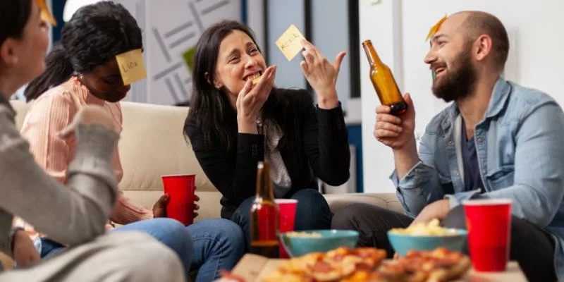 Stylish adults playing games like Twister and Pictionary in a chic, modern room with colorful props, balloons, and dramatic lighting, creating a playful yet elegant atmosphere.